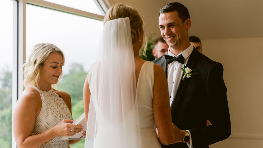 A smiles at his bride during their wedding ceremony in the chapel at Tiffanys Maleny.