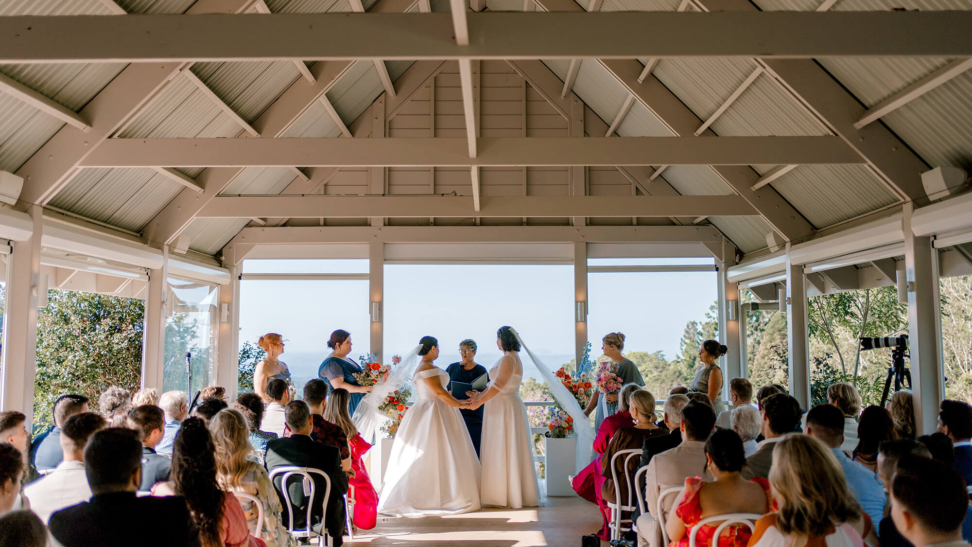 Two brides getting married at their ceremony in the Sandstone Pavillion at Maleny Manor.