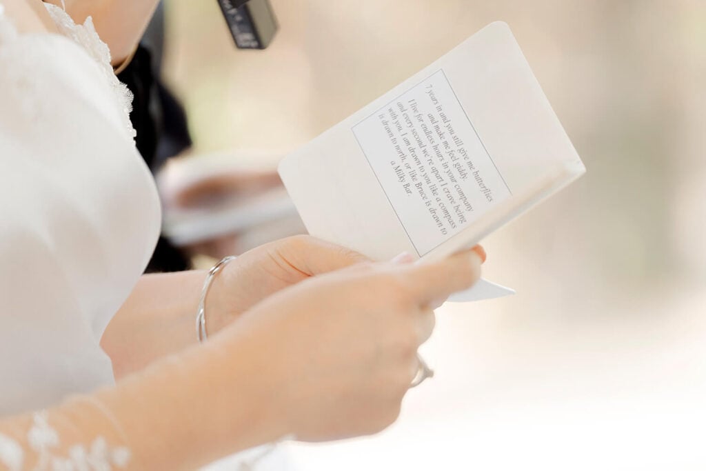 a bride reading from a love letter vow book during a wedding ceremony