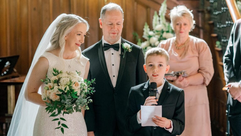 A child reads Getting Married Means You'll Have at a wedding ceremony